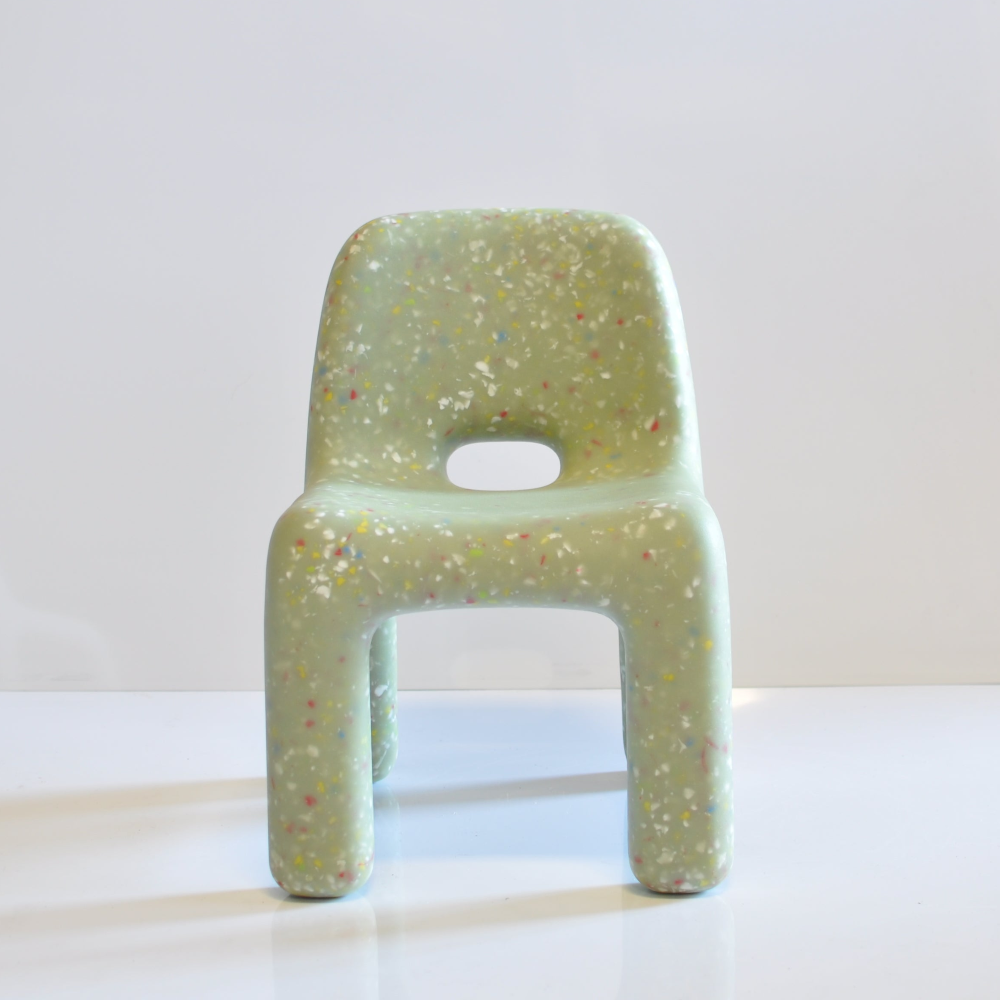 Speckled confetti kids green chair on a white surface with a light gray background