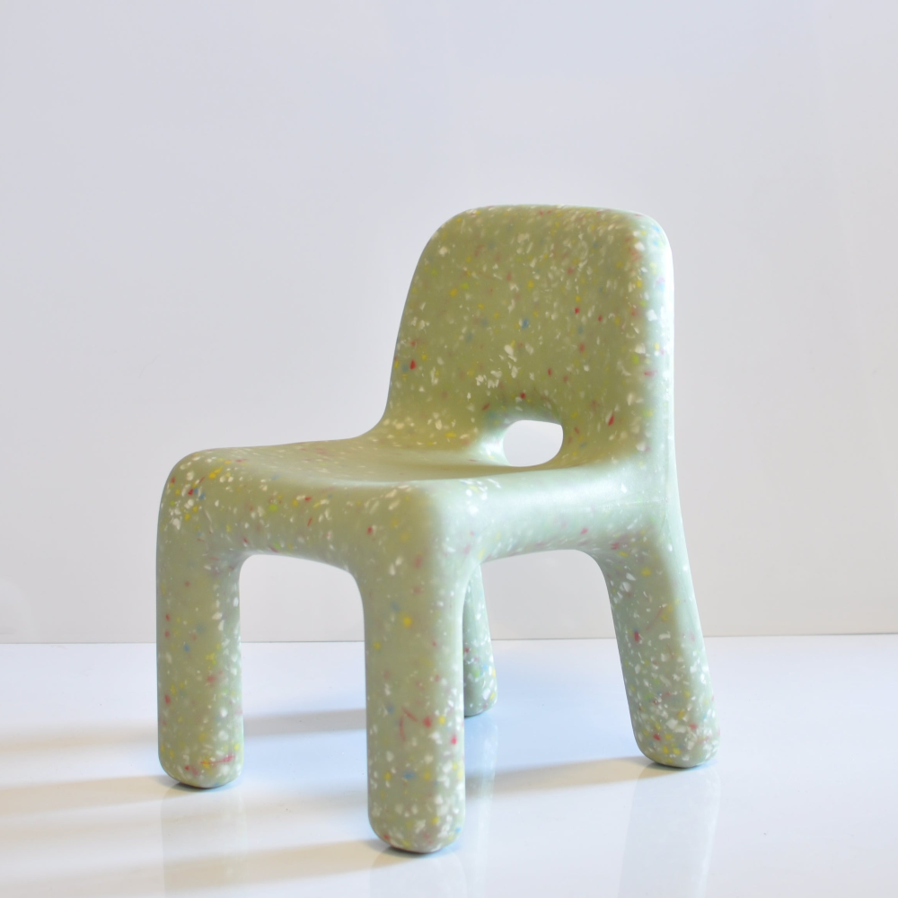 Green confetti kids chair on a white surface with a light gray background