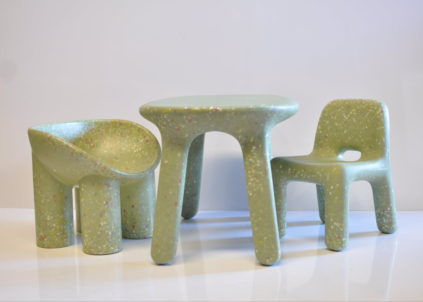 Set of green speckles confetti children's chairs and table on a white background