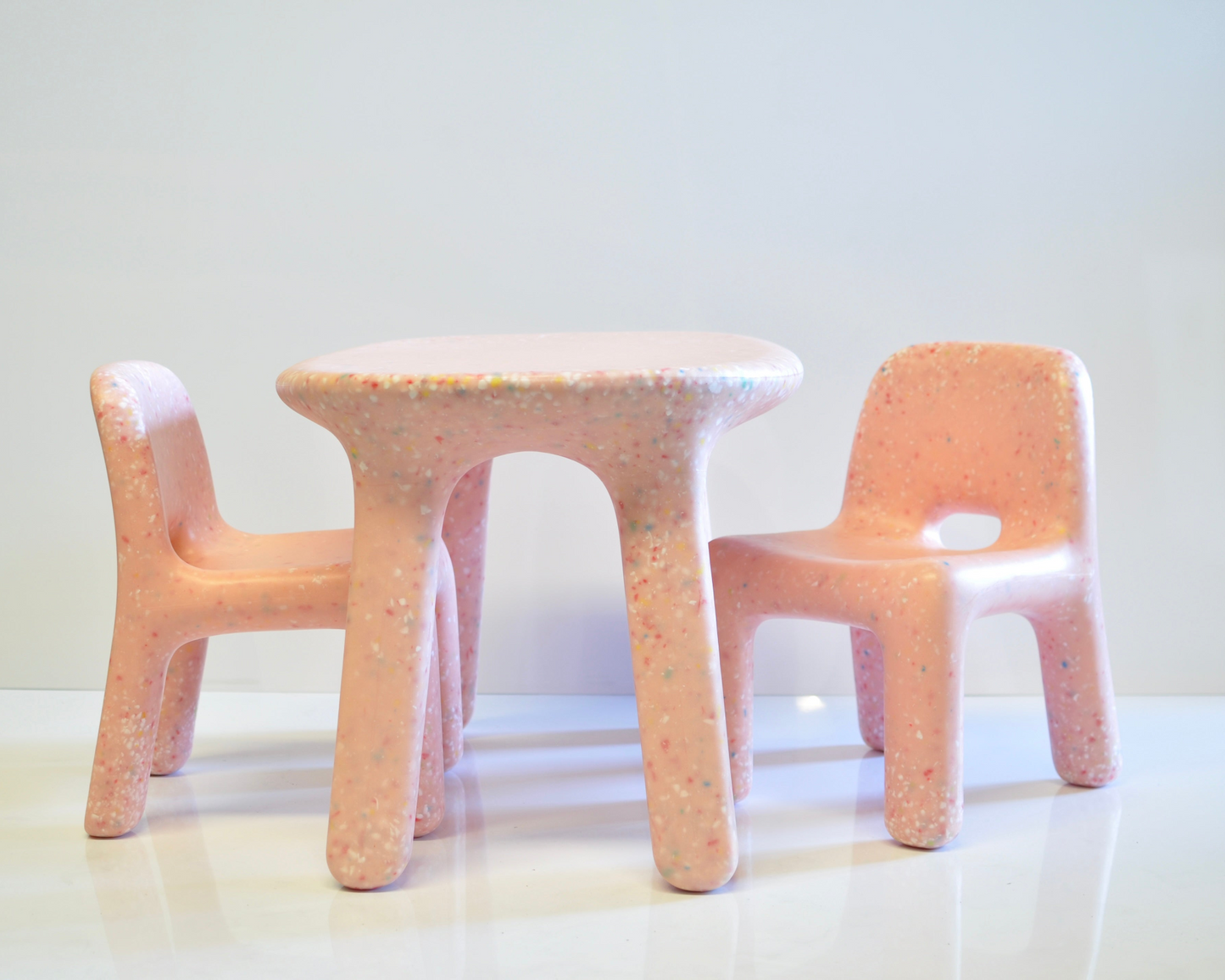 Set of three kids confetti table and chairs in colour pink blossom with a textured surface on a white background