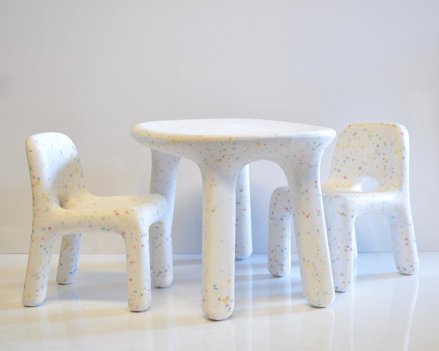 White speckles confetti children's table and chairs with a textured surface on a white background