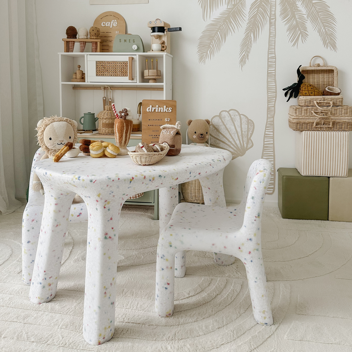 two little girls sitting in the garden playing high tea on a kids pink speckles confetti table and chair set 