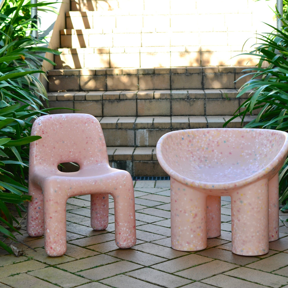 two pink kids speckles confetti chairs with steps in the background and greenery on the sides