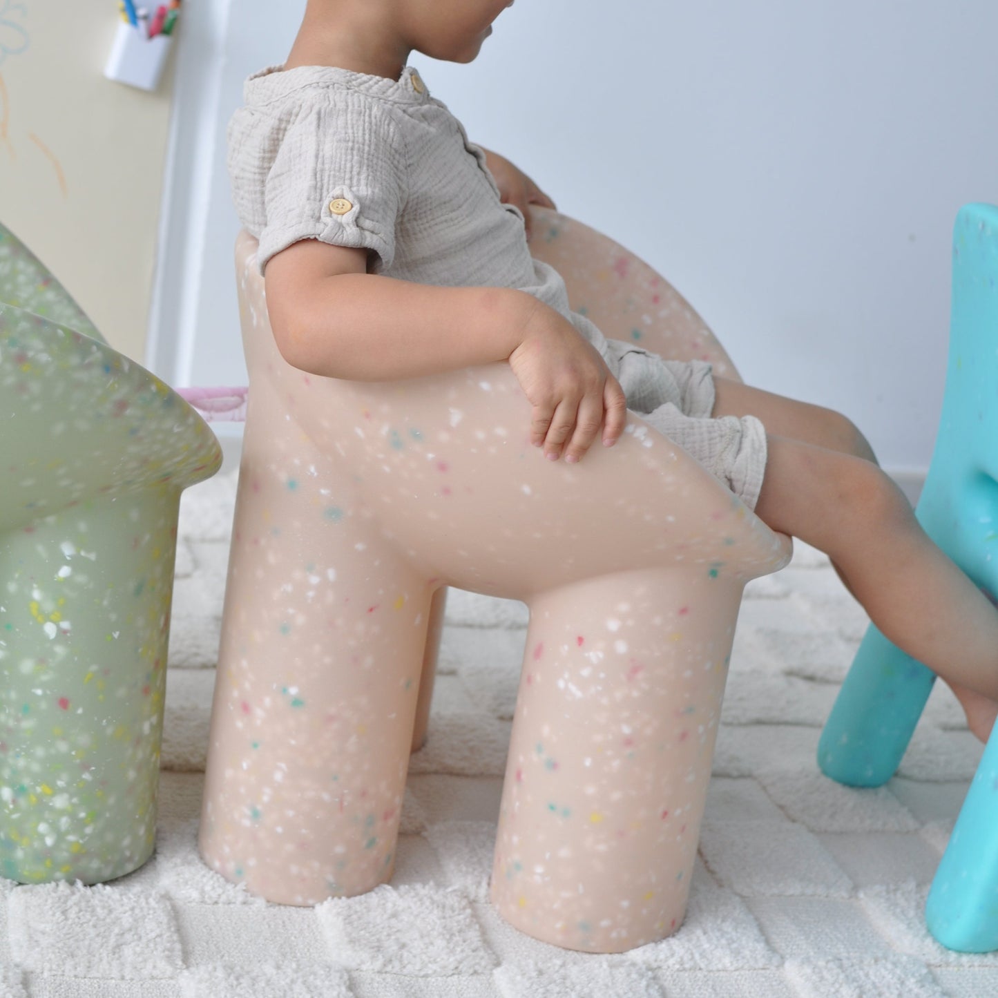 boy sitting on beige roly poly children chair