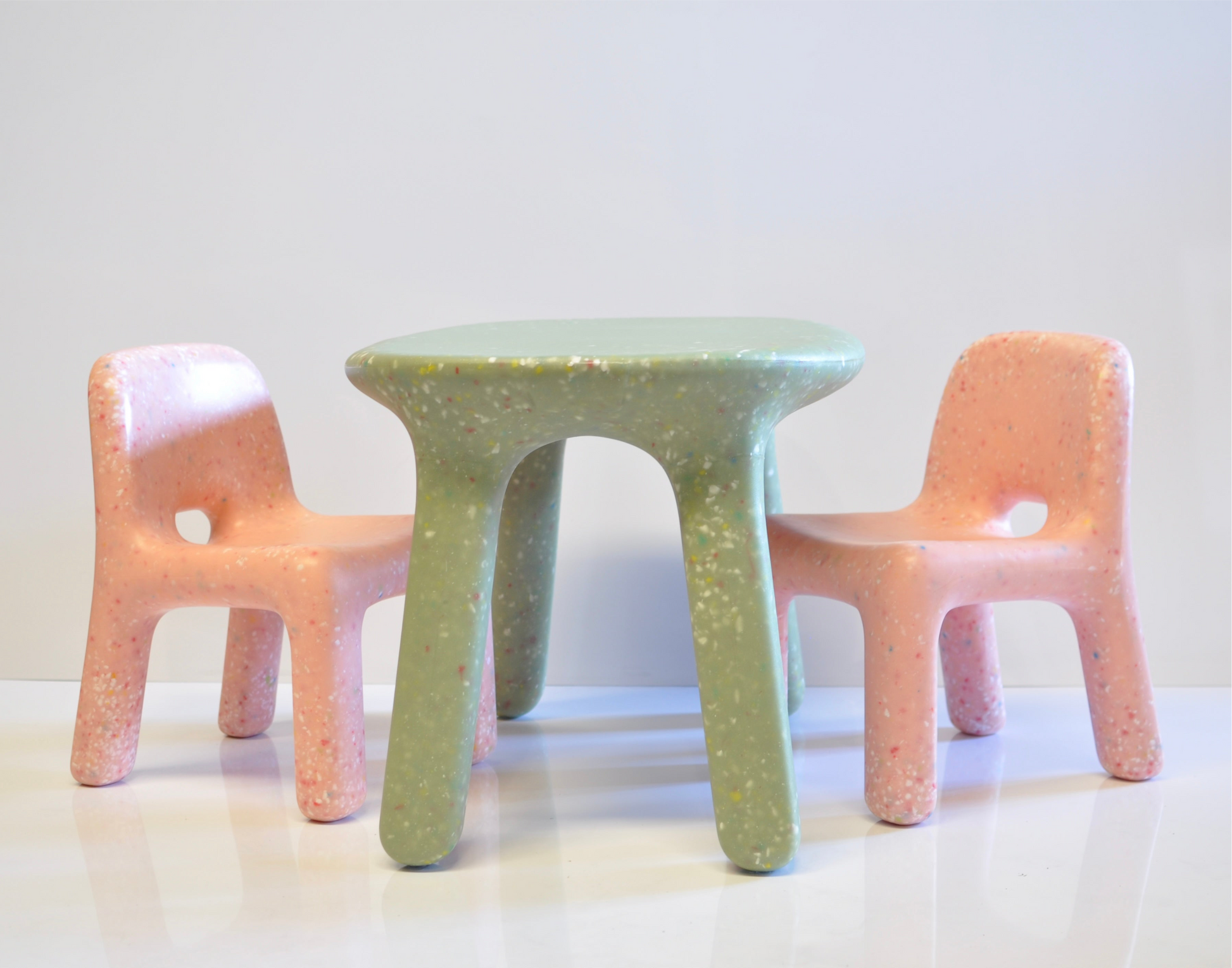 Confetti kids green table and 2 chairs in pink on a grey studio background