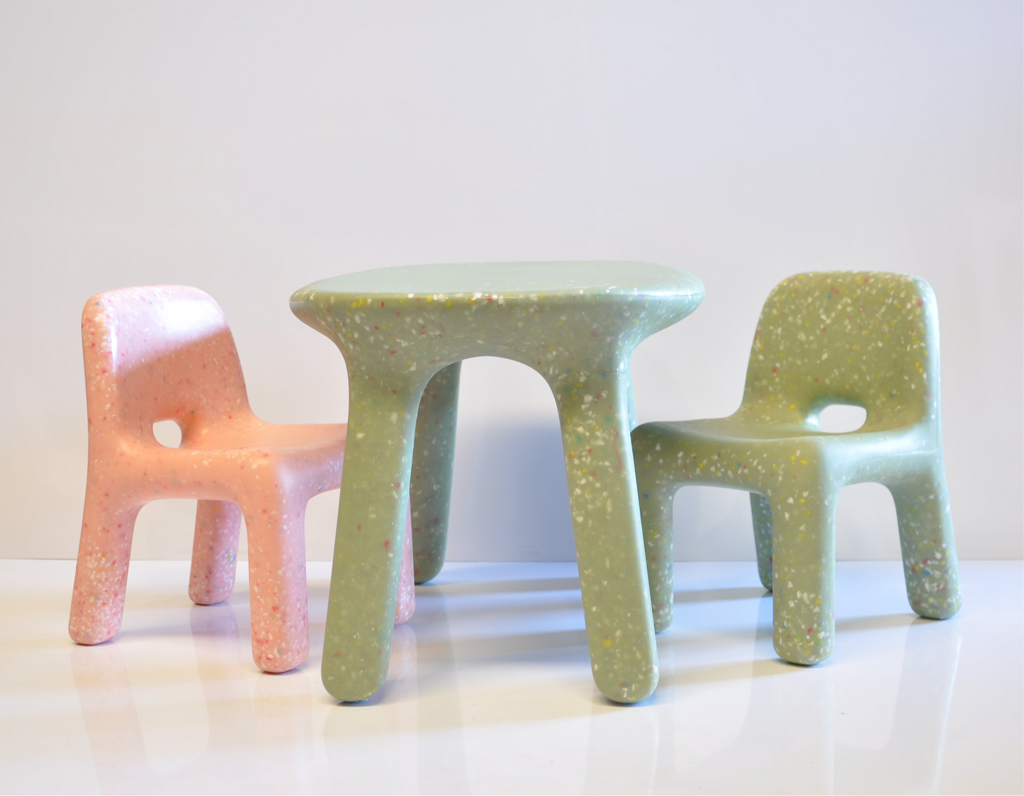 Confetti kids green table with 2 chairs in green and pink on a grey white background 