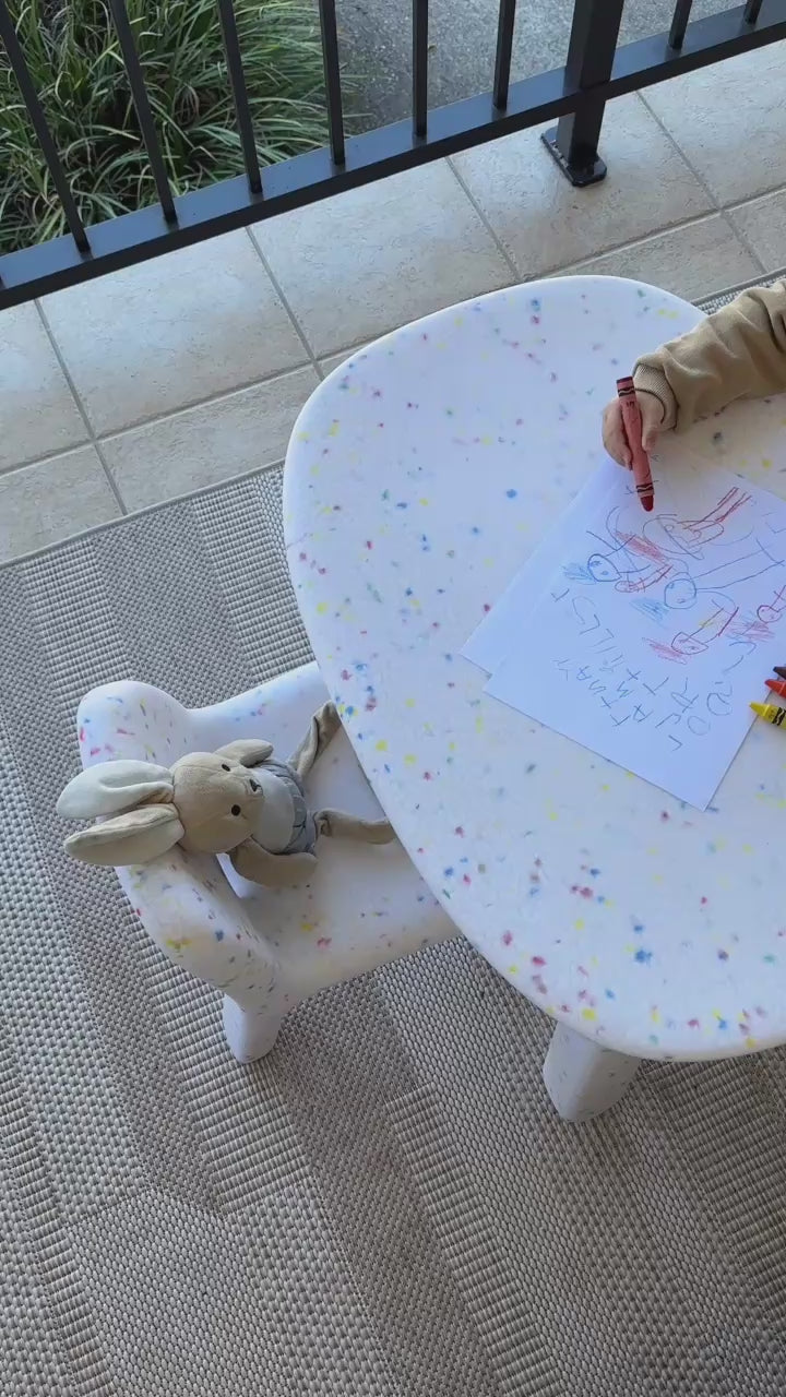 Load video: white Speckled confetti table set featuring a boy playing with colourful crayons on a balcony in daylight