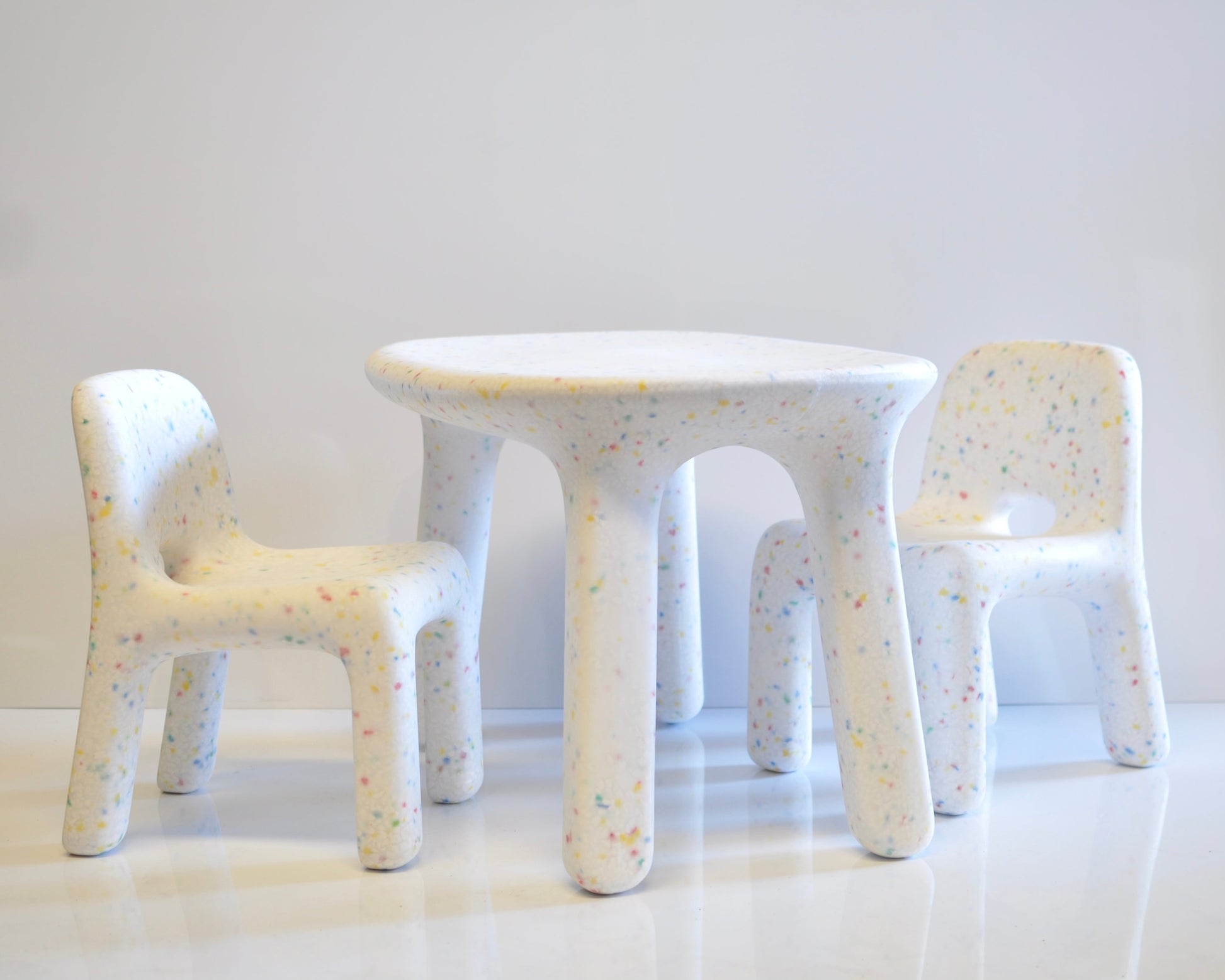 White speckles confetti children's table and chairs with a textured surface on a white background